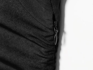 Detailed shot of an invisible zipper closure and pleated fabric on a black dress
