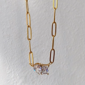 Dettaglio macro della collana a graffetta placcata oro 18k con zirconi cuore e rettangolo
