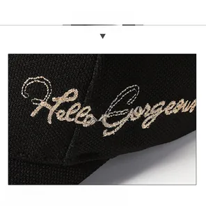 Detailaufnahme der goldenen Hello Gorgeous 3D-Stickerei auf einer schwarzen Baseballkappe