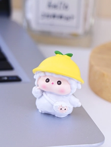 Close-up of cute mini figure with yellow hat and sheep bag on a desk workstation