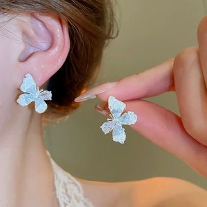 Detailed view of butterfly pearl earrings with gradient crystal and silver needles