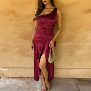 Detail view of burgundy satin dress showing one-shoulder design and high slit leg cutout