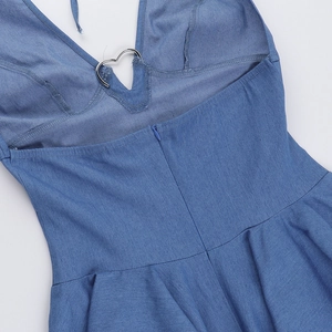 Dettaglio dell'abito in denim blu con fibbia in metallo a cuore e cerniera posteriore