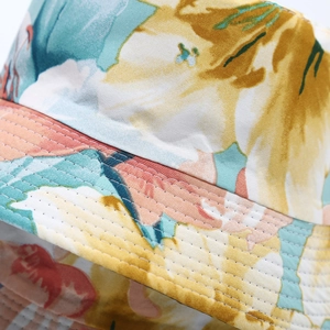 Close-up of floral bucket hat showing colorful pattern and reinforced multi-row stitching