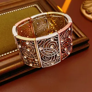 Vintage style tricolor hollow metal bracelet with rhinestones on a leather background
