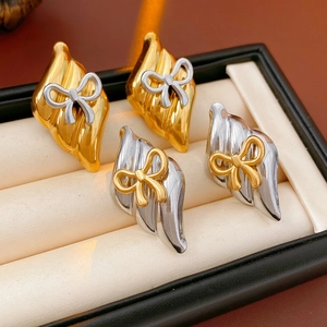 Detail of silver needle bow earrings in mixed gold and silver tones on jewelry box