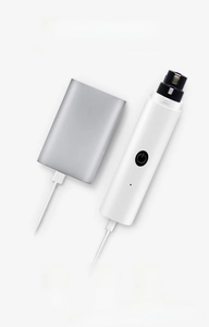 Detail of the white electric pet nail grinder connected to a power bank for USB charging