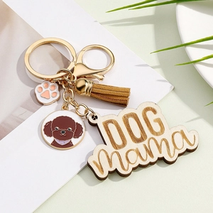Detail of Dog Mama wooden keychain with brown poodle charm and suede tassel accessory