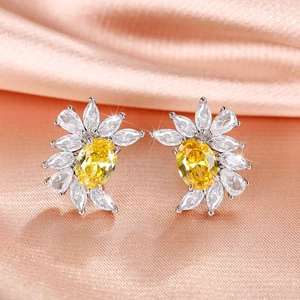 Macro view of flower-shaped stud earrings with yellow oval stone and marquise crystals