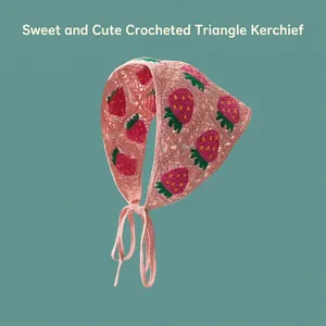 Detailed view of pink crochet bandana featuring red strawberry embroidery and ties