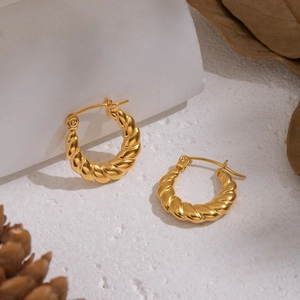 Macro shot of 18K gold plated twisted rope hoop earrings on a minimalist white backdrop
