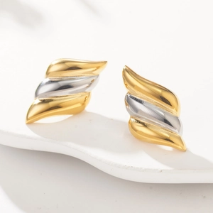 Detailed macro shot of layered two-tone wave earrings with a polished metallic finish