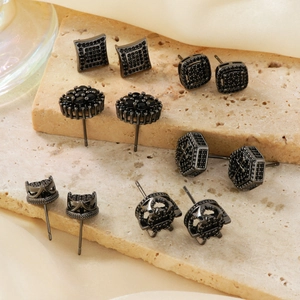 Minimalist black zircon stud earrings set for men and women on a marble stone surface