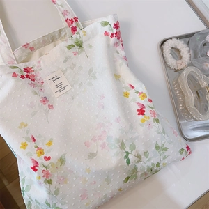 Detail of floral cotton tote bag featuring 3D polka dot texture and a vintage patch label