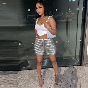Street style shot of silver metallic quilted puffer shorts and white halter top on model