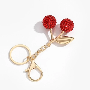 Détail du porte-clés cerise en résine pailletée rouge avec feuille dorée et fermoir