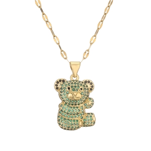 Detailed view of 3D bear pendant with green crystals on a gold chain necklace