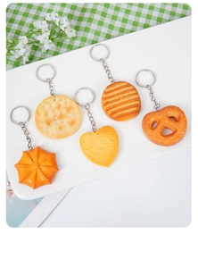 Detailed view of PVC cookie keychains in various shapes on a rustic grid background
