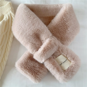 Close-up of soft pink faux fur scarf texture with a woven label on a knit sweater