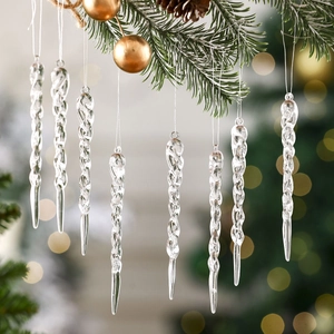 Transparent acrylic icicle ornaments hanging on a Christmas tree with golden lights