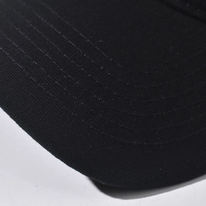Close-up of black cotton baseball cap brim with six rows of reinforced stitching