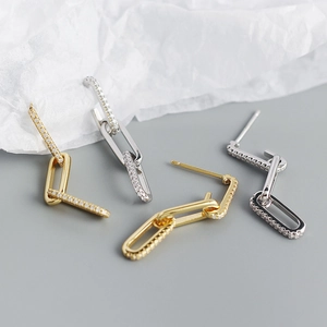 Macro detail of gold and silver chain link earrings with pavé cubic zirconia accents