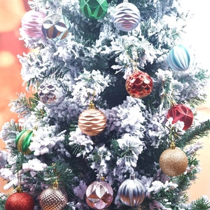 Set of 12 colorful 6cm painted Christmas ball ornaments hanging on a snowy tree