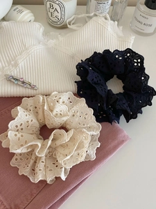 Détail de chouchous en dentelle blanche et marine avec barrette à cheveux en strass chic