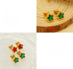 Detailed view of star-shaped earrings with red and green cubic zirconia and gold plating