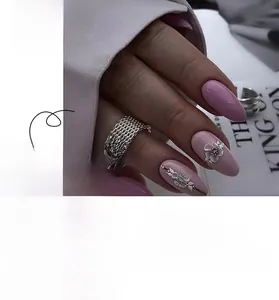 Detail of pink French press-on nails featuring 3D white flowers and pearl embellishments