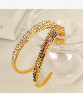 Macro detail of gold hoop earrings with multi-colored pavé zircon and white crystals