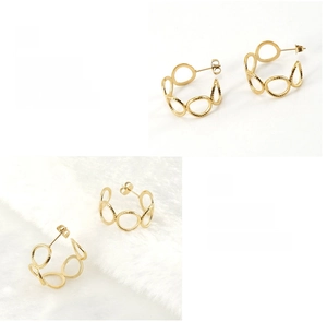 Detail view of 18K gold hollow C-shape earrings showing polished plating and twisted texture