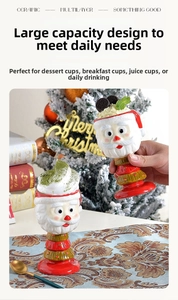 Detail of Santa Claus ceramic mug with red base near a festive Christmas tree