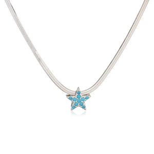 Macro shot of silver snake chain necklace featuring a blue zircon star-shaped pendant