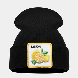 Detailed close-up of a black knit beanie featuring a yellow lemon embroidery patch