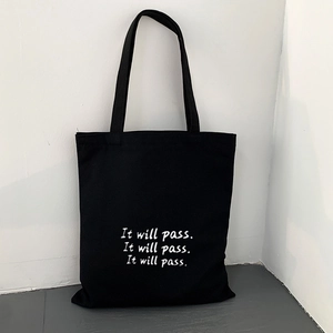 Detail der schwarzen Canvas-Tasche mit weißem It will pass-Schriftzug im minimalistischen Stil