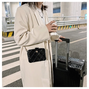 Fashionable black quilted PVC jelly bag with gold chain strap on a stylish model