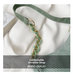 Detail of sage green corduroy shoulder strap with gold metal and acrylic chain links