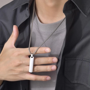 Close-up of a silver rectangular bar pendant on a minimalist stainless steel chain for men