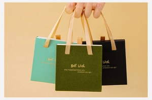 Minimalist drawer jewelry boxes in green and black with silk handles and gold text