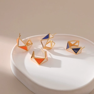 Detail of geometric C-shaped hoop earrings with colorful enamel drip oil finish