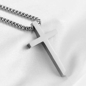 Vue macro d'un pendentif croix poli de 45mm sur une chaîne à billes en acier inox