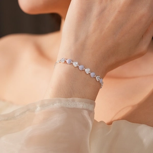 Close-up of silver bracelet with lavender heart-shaped stones and pavé zircon details