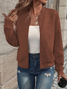 Close-up of brown bomber jacket with textured fabric and metallic zipper detail