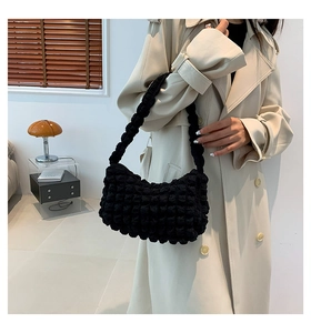 Gros plan du sac à bandoulière noir à texture popcorn avec tissu chic et bandoulière