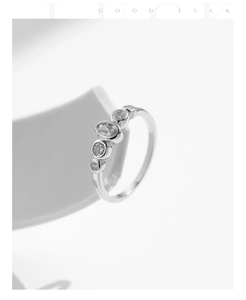 Macro detail of silver geometric five-stone ring with sparkling bezel-set oval zircon stones
