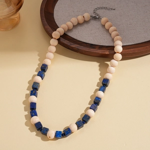 Détail de perles de bois bohèmes et de pierres carrées bleues sur collier de chandail