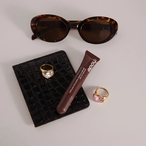 Flat lay of gold stainless steel rings with pink and clear heart rhinestones and props
