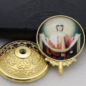 Close-up of golden metal religious base with Virgin Mary icon and relief patterns