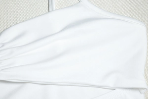 Dettaglio del tessuto bianco elasticizzato con cuciture precise e trama liscia